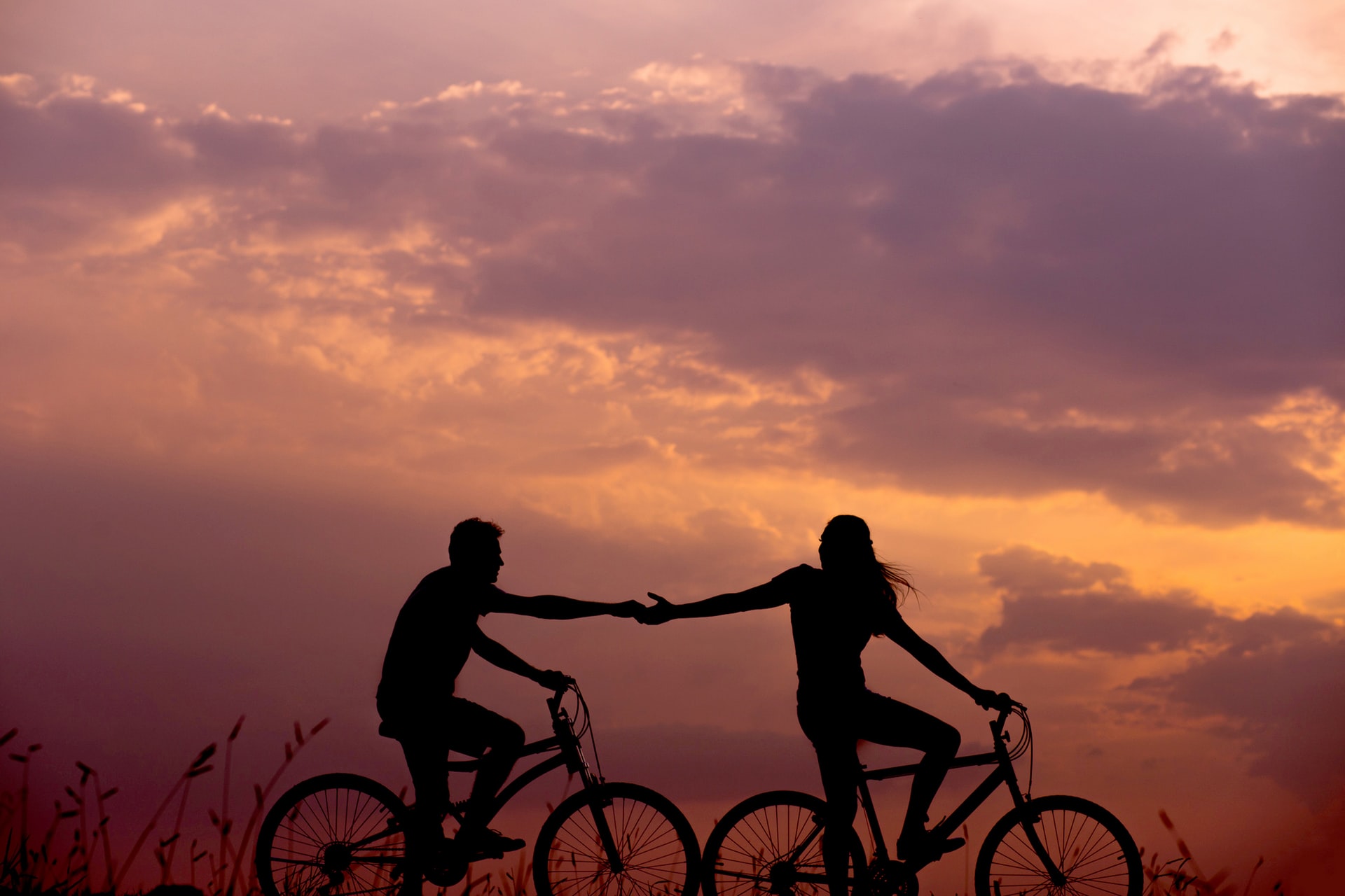 two people on bikes at sunset
